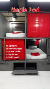 皮皮岛Dormsin Social的一间设有三张双层床和红色标志的房间
