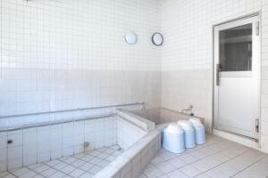 Hinoリバーサイドひの的白色的浴室设有浴缸和2个卫生间