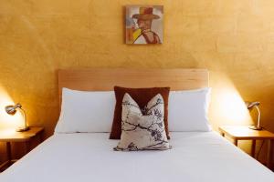 弗林德斯山脉普瑞宾馆的卧室配有带两盏灯的白色床