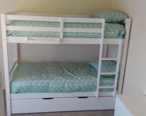 ArdrossanEagles Nest - Ardrossan的配有两张双层床的客房,配有绿色床单