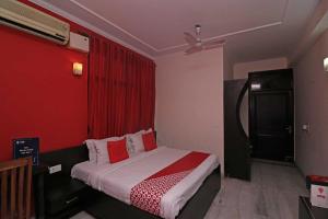 BhiwadiOYO Flagship 80902 Swagat Hotel的一间卧室配有一张红色墙壁的床