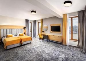贝谢诺瓦Hotel Akvamarín的一间卧室配有一张床、一张书桌和一台电视