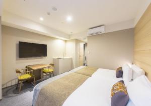 札幌札幌东急酒店的酒店客房设有一张大床和一张书桌。
