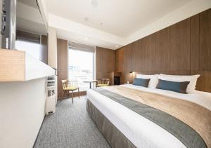 札幌札幌东急酒店的酒店客房设有一张大床和一张桌子。