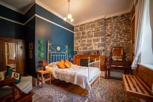 斯坦利Poet's Cottage Stanley的一间卧室设有一张床和石墙