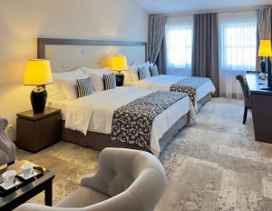克拉科夫大都会精品酒店的酒店客房,配有两张床和椅子