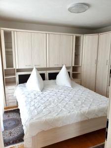 弗罗伊登施塔特Blackforest FeWo的卧室配有一张带内置橱柜的大型白色床。