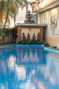 乌布Townhouse, Pool & Kitchen, Ubud, Cucus Mondok的一个带喷泉的大型蓝色游泳池
