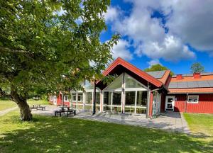 林雪平Valla Folkhögskola的一座红色的建筑,设有野餐桌和一棵树
