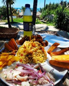 洛斯拉甘斯Marcilia Beach Bungalows的饭和一瓶啤酒的盘子