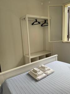 托雷拉皮罗Holiday Home Eurovillage的一间卧室,在床上配有两张毛巾和镜子