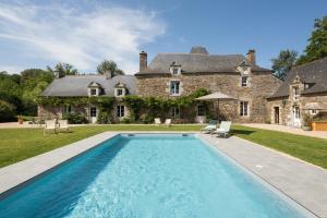 MalansacMANOIR DU VAU D ARZ gîtes et chambres d hôtes avec piscine的房屋前带游泳池的庄园