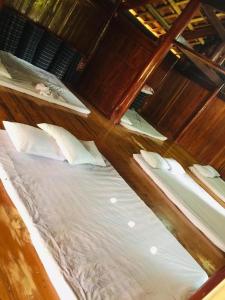 木州县Homstay Sinh thái Cây Sung Mộc Châu的一间卧室配有带白色床单和枕头的床。