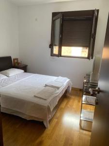 贝西奇Apartment in Becici的卧室配有白色的床和窗户。