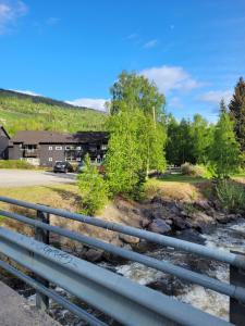 哈山Friends & Family Apartment at Hafjell Alpinlandsby/Øyer Center的一座河上的桥梁,有一座建筑的背景