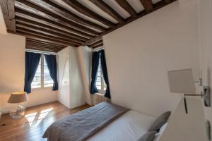 巴黎Colonnade的一间卧室设有一张床和两个窗户。