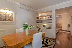 阿雷佐Residence Gello的一间带木桌和白色椅子的用餐室