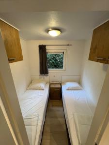 洪德洛Chalet Hoenderloo的小型客房 - 带2张床和窗户