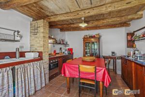 奥西莫Casa dei Pini Country House的厨房配有一张带红色桌布的桌子