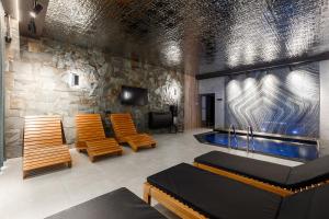 BohorodchanyUnderhill Resort&Spa的一个带游泳池和木椅的房间