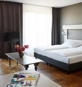 柏林Hotel AMANO Rooms & Apartments的酒店客房,设有两张床和一张茶几
