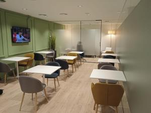 马德里HelloSky Air Rooms Madrid的一间设有桌椅和墙上电视的客房