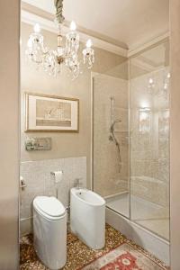 博洛尼亚Castellata La Suite的一间带卫生间和淋浴的浴室以及吊灯。
