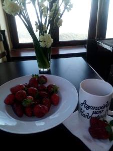 IsarisHotel Isaraiko Spiti Agia Theodora的茶几旁的桌子上放上草莓的盘子