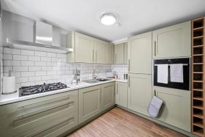韦克菲尔德Beautiful 2 Bedroom Apartment in Central Wakefield的厨房配有白色橱柜和炉灶。