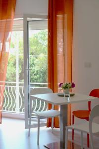 Villaggio RestaCamera & Caffè - Accoglienza Salentina的窗户客房内的白色桌椅