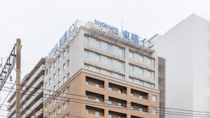 宫崎Toyoko Inn Miyazaki Ekimae的上面有标志的建筑