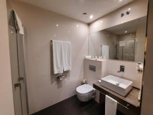 马德里HelloSky Air Rooms Madrid的一间带水槽、卫生间和镜子的浴室