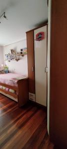 桑托尼亚APARTAMENTO 2 HABITACIÓNES con GARAJE EN SANTOÑA的一间带一张床和一个衣柜的小卧室
