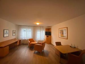 曼海姆阿里瓦博丁普拉塔南花园住宅酒店的客厅配有桌椅和书桌。