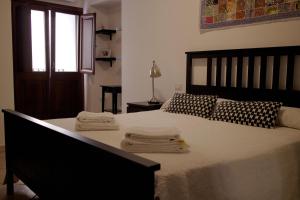 博萨Sardinian Gallery Corso的一间卧室配有一张大床和毛巾
