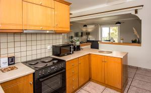 拉基索拉Aristotelis Apartment Lakithra-Alexandra的厨房配有木制橱柜和黑炉灶烤箱。