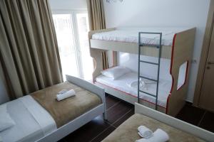 维利波吉Fishta Apartment Q6 37的小房间设有两张双层床和窗户
