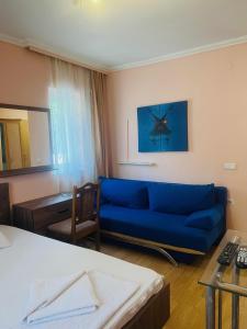 普里什蒂纳Guest House Velania的客厅配有蓝色的沙发和书桌