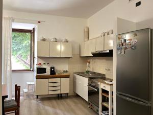 Serra San QuiricoLa Piazzetta的厨房配有白色橱柜和冰箱。