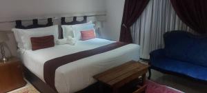 MmadinareMmathaba Guest House的一间卧室配有一张大床和一张蓝色椅子