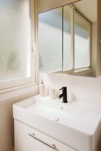 拉西约塔Cozy room on the beach的浴室设有白色水槽和镜子