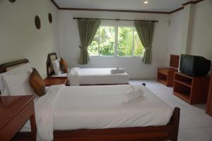 茶云莱海滩查汶海塔拉酒店的一间卧室配有两张床和电视。
