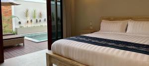 塞隆贝拉纳克Pandan Villas的一间卧室设有一张床,阳台设有游泳池