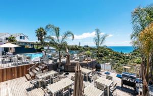 棕榈滩Cosy Palm Beach Cottage with Spectacular Seaviews的一个带桌子和遮阳伞的庭院和大海