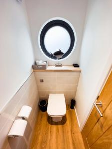 卡迪夫Rooms at The Deck, Penarth的一间带卫生间的小浴室和圆形窗户