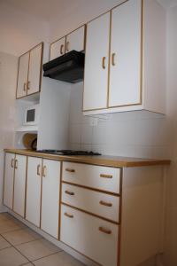 昆斯敦Cozi Corner的厨房配有白色橱柜和炉灶。
