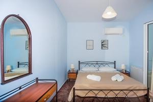 拉基索拉Aristotelis Apartment Lakithra-Lydia的一间蓝色卧室,配有一张床和镜子