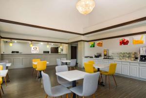 韦科贝勒体育场北品质酒店的一间设有黄色桌椅和柜台的餐厅
