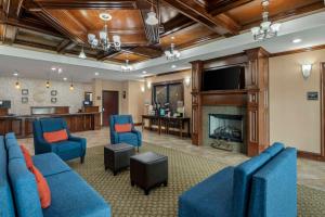 沃思堡Comfort Inn & Suites Fort Worth - Fossil Creek的客厅配有蓝色的家具和壁炉