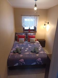 伊斯泰布纳Domek na Polance的一间卧室配有一张带紫色棉被的床